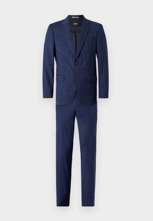 Un costume bleu marine avec un blazer à deux boutons et revers crantés, un pantalon à plat et une texture subtile sur l'ensemble du tissu.