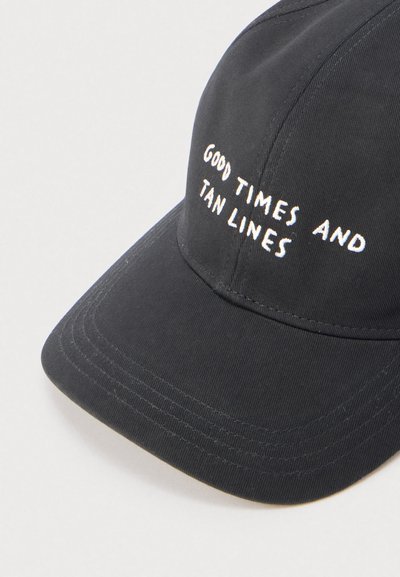 Μαύρο καπέλο μπέιζμπολ με καμπυλωτό γείσο κεντημένο με τη φράση «GOOD TIMES AND TAN LINES» σε λευκά κεφαλαία γράμματα.