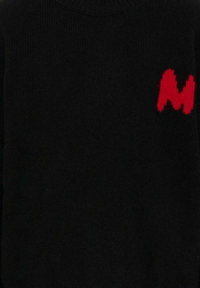 Maglione nero a maglia con colletto alto e texture a coste; presenta un logo rosso pixelato a forma di "M" sulla parte sinistra del petto.