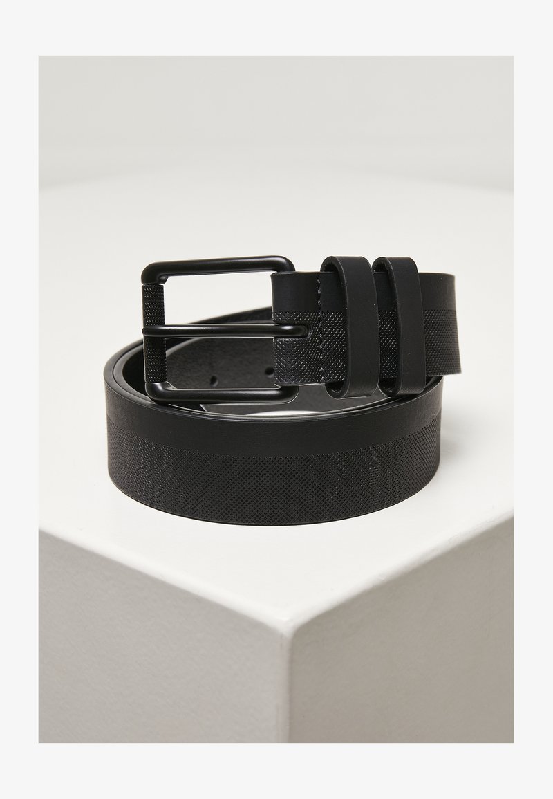 Black belt with a textured surface, featuring a matte finish and a rectangular metal buckle. The design incorporates a smooth band and two buckle loops.