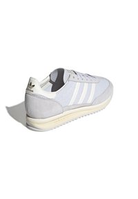 Light gray athletic shoe with a breathable mesh upper, suede accents, three white stripes, and a cream-colored rubber sole.