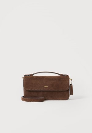 Sac à main en cuir suédé marron avec poignée supérieure et bandoulière détachable, avec un petit logo doré sur le rabat avant.
