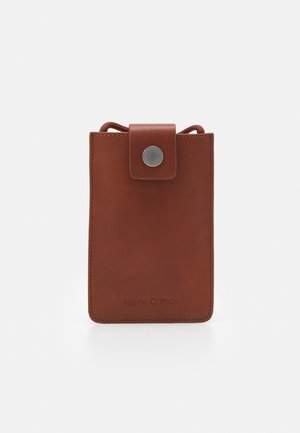 Bruine leren portemonnee met een klep met drukknop en zichtbare stiksels, met Marc O'Polo branding aan de onderkant in het midden.