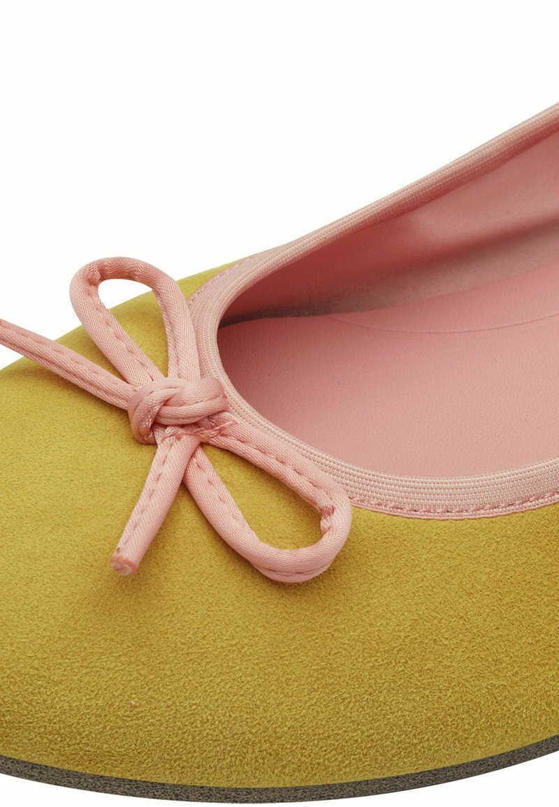 Ballerina in suede giallo con un fiocco in tessuto rosa sul davanti e fodera interna rosa. Design elegante con punta arrotondata.