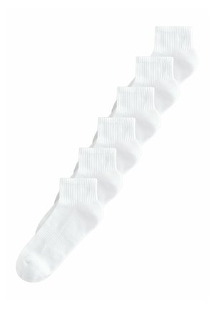 Hat fehér, bokáig érő zokni bordás szegéllyel, átlósan elrendezve fehér háttéren.