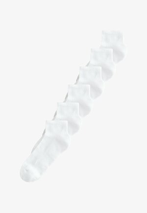 Šeši balti kulkšnies ilgio kojinai su ribotu apvadu, išdėstyti įstrižai ant balto fono.