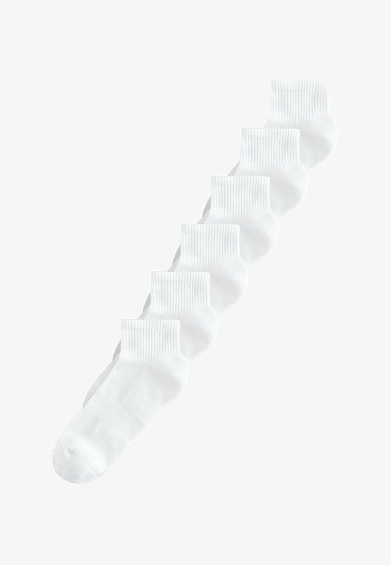Six chaussettes blanches jusqu'à la cheville avec des bordures côtelées disposées en diagonale sur un fond blanc.