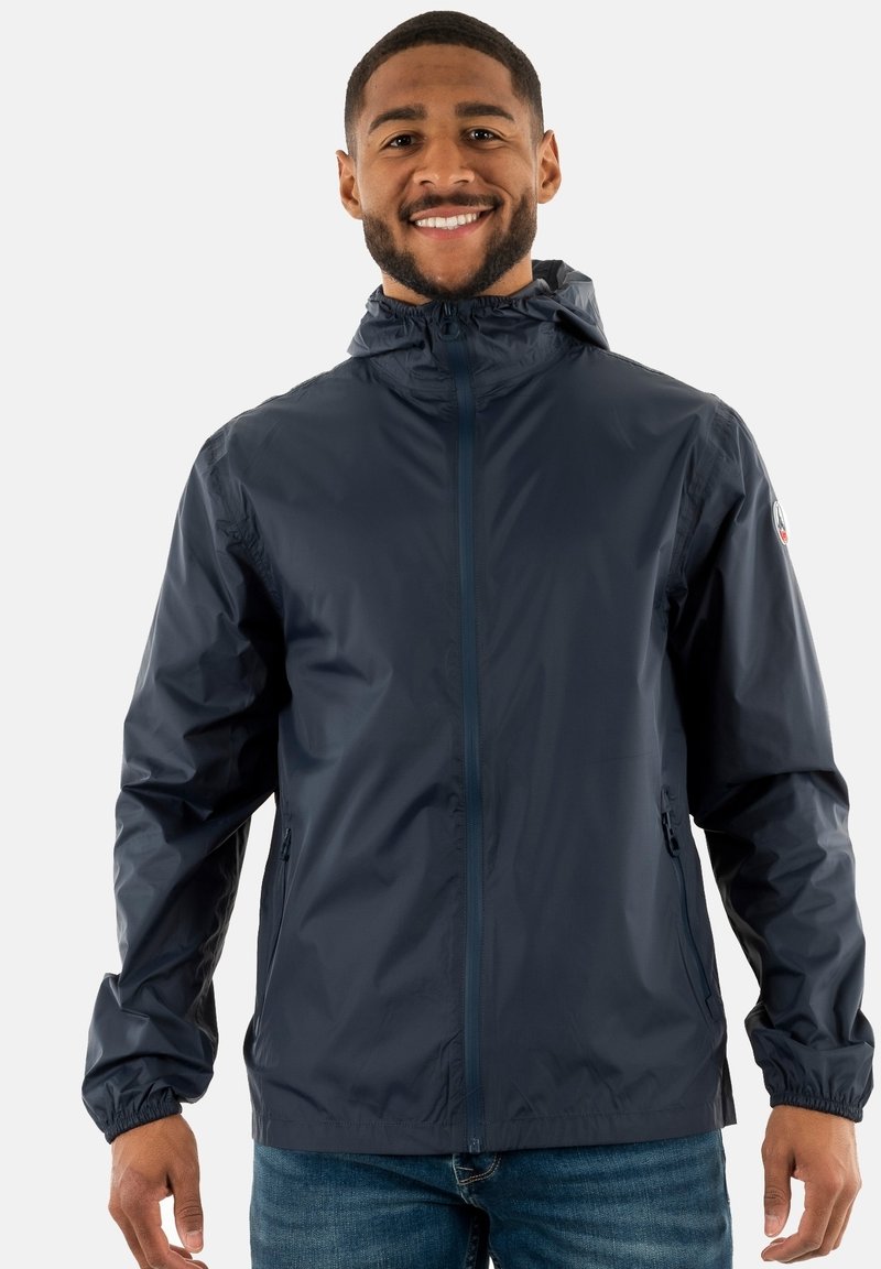 Veste à capuche navy en matériau léger et résistant à l'eau, avec des poignets élastiques, deux poches latérales et une fermeture éclair complète. Logo sur la manche.