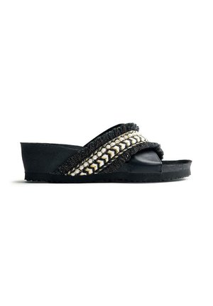 Sandalia de cuña negra tipo slide con tiras decorativas trenzadas en negro, blanco y dorado sobre la parte superior y diseño de punta abierta.