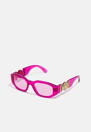 Gafas de sol rosas y transparentes con montura angular, lentes degradados rosas y acentos de hardware en tono dorado en las patillas.