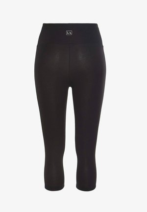 Leggings capri negros con una cinturilla ancha y un pequeño logo. La tela tiene una textura suave y un diseño ajustado.