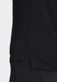 Schwarzes Sportshirt mit glatter Textur, ausgestattet mit einem seitlichen Schlitz am Saum und kurzen Ärmeln für eine figurnahe Passform.