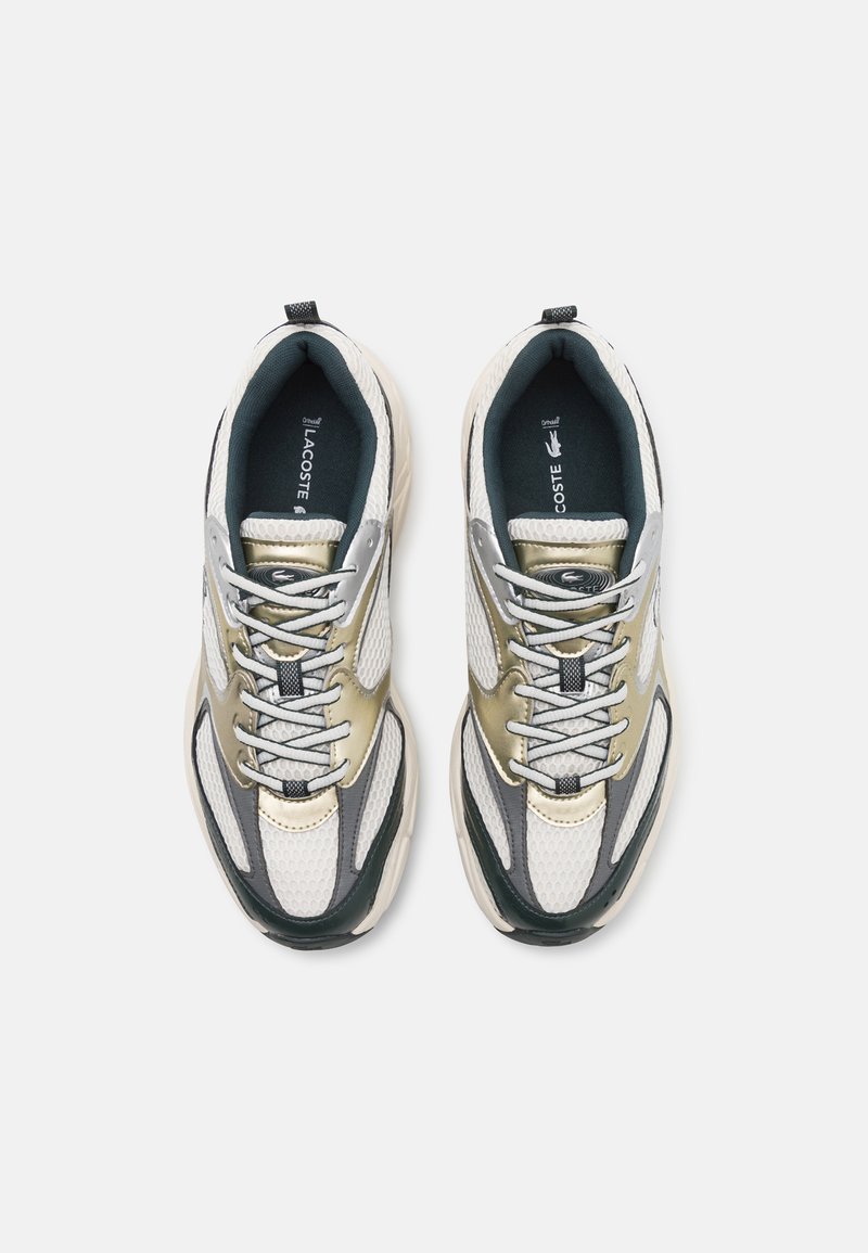 Sneakers Lacoste in beige, bianco e verde scuro. Parte superiore in mesh e pelle con chiusura a lacci, collo imbottito e suola testurizzata.