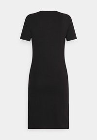 Musta lyhythihainen mekko, jossa istuva siluetti. Valmistettu pehmeästä kankaasta, siinä on pyöreä pääntie ja se yltää juuri polven yläpuolelle.