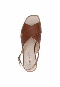 Sandale en cuir marron avec un design entrecroisé, bout ouvert et bride de cheville. Caractéristiques d'une finition lisse et d'un intérieur léger.
