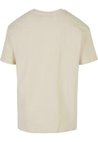 Kortermet T-skjorte i lys beige bomull, med rund hals og et enkelt, uten ornamenter design med en jevn tekstur.