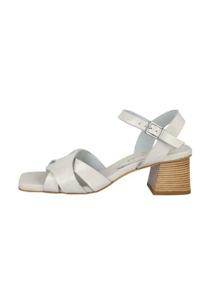 Sandalia de cuero blanco con tiras cruzadas y diseño de punta cuadrada. Un modesto tacón de bloque con acabado en madera natural añade estabilidad.