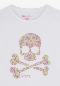 Witte katoenen t-shirt met een roze en groene luipaardprint van een doodskop met gekruiste botten, met het woord "Scalpers" in een cursieve lettertype.