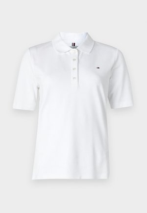 Λευκό πόλο μπλουζάκι από βαμβάκι με κλασικό γιακά, κοντά μανίκια, πλάκα με τρία κουμπιά και ένα μικρό λογότυπο στο στήθος.