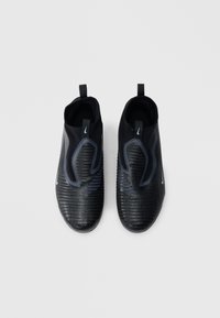 Μαύρα αθλητικά παπούτσια χωρίς κορδόνια με υφή επιφάνειας, διαθέτουν ραβδωτό σχέδιο, μπλε λεπτομέρειες και λουράκια για εύκολο φόρεμα.