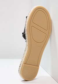 Svart espadrille-sula med juteinnslag, platt plattform och texturerad gummibas. Storlek 37 märkt på basen, märkt "Tillverkad i Spanien."