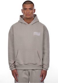 Lys grå hoodie lavet af bomuldsblanding med en frontlomme, ribbede manchetter og kant, samt et lille hvidt logo på venstre bryst.