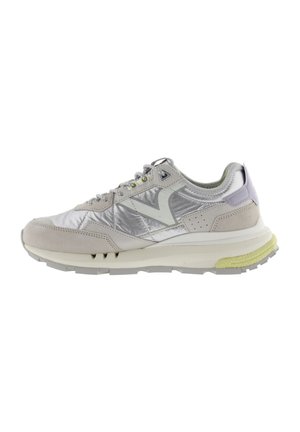 Sneaker grigio chiaro caratterizzato da un mix di pelle liscia e tessuto lucido, con un logo distintivo, accenti perforati e una suola gialla texturizzata.