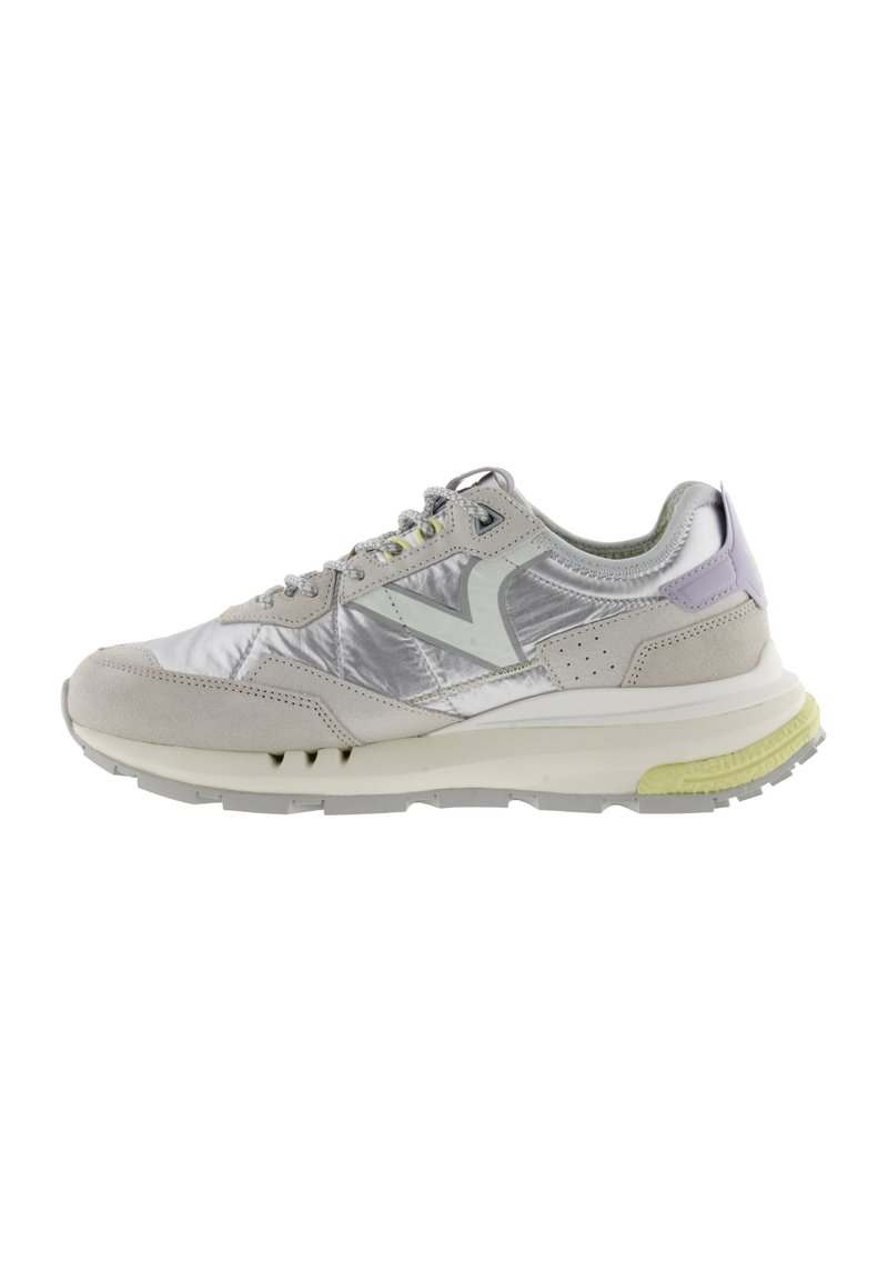 Sneaker grigio chiaro caratterizzato da un mix di pelle liscia e tessuto lucido, con un logo distintivo, accenti perforati e una suola gialla texturizzata.