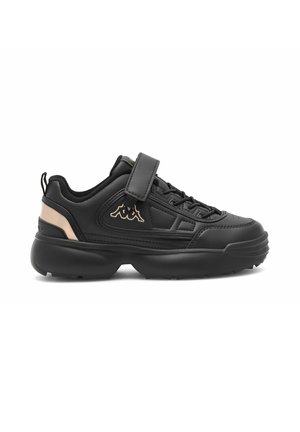 Czarny niski sneaker z grubą podeszwą, sznurowadłami i paskiem na rzep, wyściełanym kołnierzem oraz beżowym logo i akcentem na pięcie na białym tle.