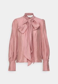 Blouse en satin rose avec de longues manches bouffantes, de larges poignets et un grand nœud noué au cou.