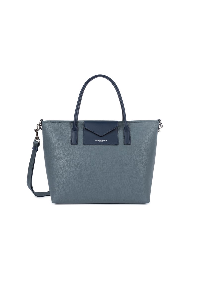 Sac fourre-tout en cuir grainé gris avec des poignées supérieures doubles et une bandoulière amovible. Présente un accent bleu marine et un détail de logo sur le devant.