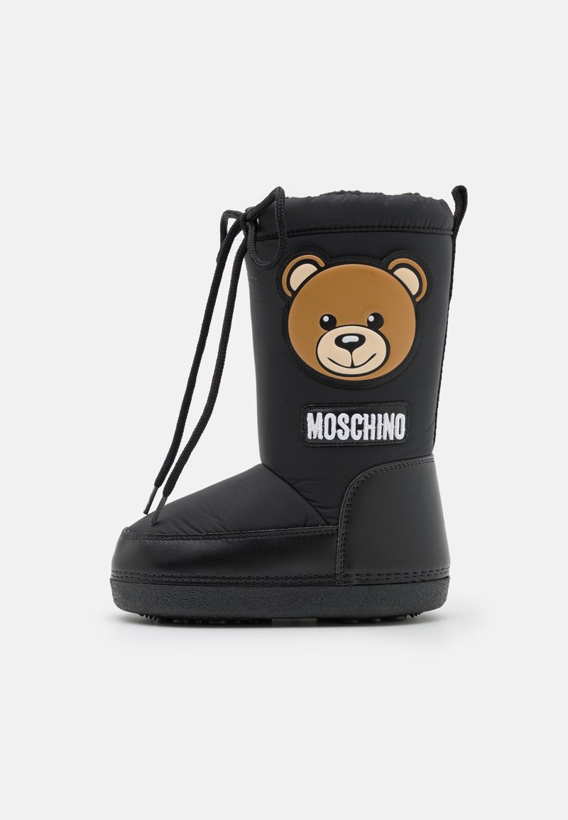 Botte d'hiver noire avec un patch visage d'ours et logo "Moschino" sur le côté, avec une fermeture à lacets en haut.