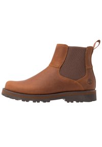 Bottes Chelsea en cuir brun avec des panneaux élastiques sur les côtés et une languette. Semelle en caoutchouc durable avec un motif cranté pour une meilleure adhérence.