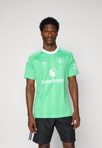 Zöld focimez függőleges csíkokkal, Adidas logóval és "Snapdragon" felirattal. Rövid ujjú, kerek fehér gallérral. Fekete rövid nadrág.