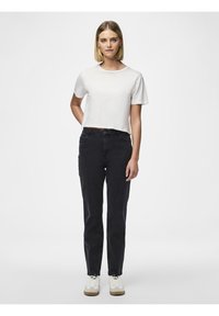 Hvit kort t-skjorte kombinert med mørke jeans. Jeansene har en jevn tekstur og klassisk fem-lomme-design, akkompagnert av hvite sneakers.