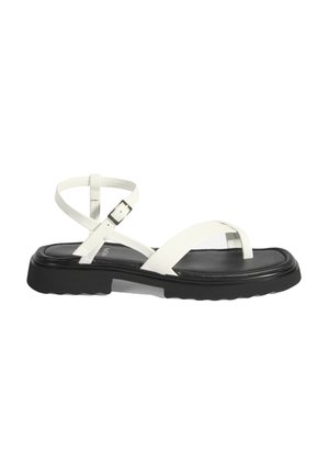 Sandales en cuir blanc avec semelle en caoutchouc noire. Les caractéristiques incluent des sangles étroites et une boucle à la cheville, une semelle plate et un design minimaliste.