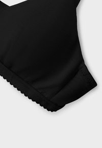 Schwarzer BH aus glattem Material, mit dreieckigen Cups, gewelltem Kantenabschluss am Band und einem nahtlosen Design für Komfort und Passform.