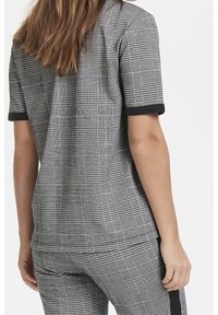 Top de manga corta a cuadros gris y negro con cuello redondo, con detalles negros en las mangas y una tela suave y texturizada.