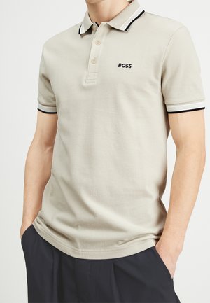 Beiges Polohemd aus strukturiertem Stoff mit einer Knopfleiste mit drei Knöpfen, schwarz-weiß gestreiftem Kragen und eingesticktem "BOSS"-Logo.