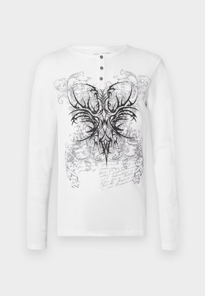 Valge pika varrukaga särk, millel on ümarsärk kaelus ja kolm musta nööpi, musta spiraalsete mustrite ja abstraktsete kujunditega trükk.