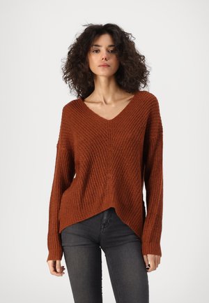 Rust-colored knit sweater with a v-neck, long sleeves, and a relaxed fit. Features a textured pattern and a slightly elongated back hem.