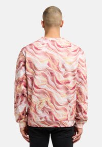 Crewneck-Sweatshirt mit einem farbenfrohen, abstrakten Wellenmuster in Rosa- und Cremetönen. Hergestellt aus strukturiertem Stoff mit langen Ärmeln.
