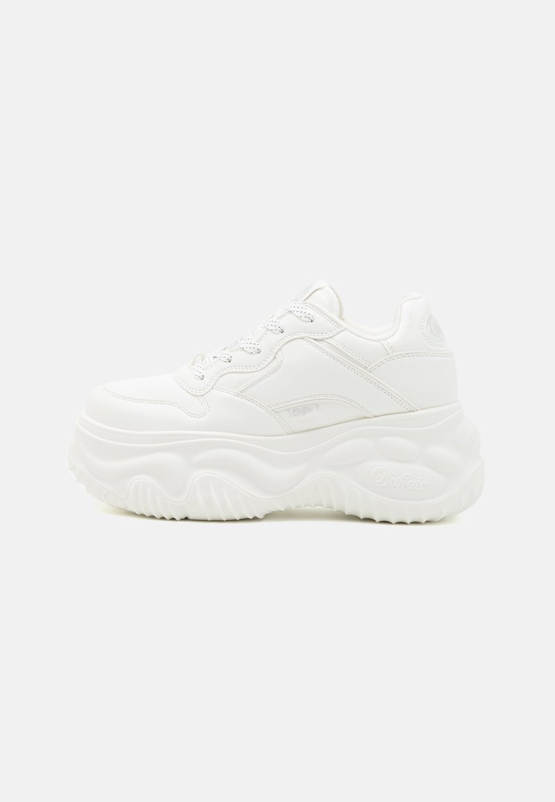 Zapatillas deportivas blancas y gruesas con parte superior de cuero liso, suela gruesa texturizada con patrones ondulados y diseño clásico de cordones.