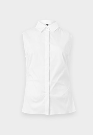 Bezroku balta krekla blūze ar smailu apkakli, gludu audumu un tīru, piegulošu siluetu.