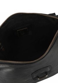 Schwarze Lederhandtasche mit einem Reißverschluss, weicher Textur und einer kleinen Tasche. Sichtbare Nähte und Metallbeschläge.