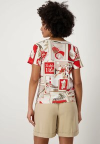 Haut pour femmes à manches courtes, multicolore, présentant un collage de motifs sur le thème de la mer en rouge, beige et vert sur un fond clair.