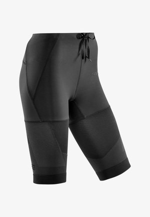 Black athletic shorts with a tight fit, smooth fabric, textured side panels, and a drawstring waist. Features logo detailing on the front.