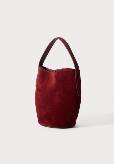 Sügavpunane sametist käekott ümmarguse kujuga ja ühe ülemise käepidemega. Sellel on sile siseosa ja laineline ülemine serv.