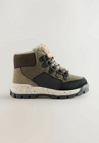Botte de randonnée pour enfant avec des panneaux verts, noirs et marrons, semelle blanche tachetée, doublure en fourrure et crochets métalliques pour les lacets.