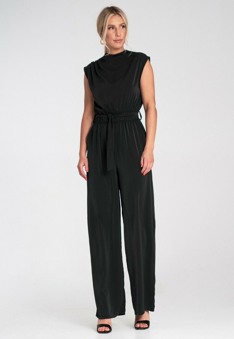 Czarny kombinezon bez rękawów z wysokim kołnierzem, elastyczną talią i pasującym paskiem, z szerokimi spodniami i gładką, zwiewną fakturą.